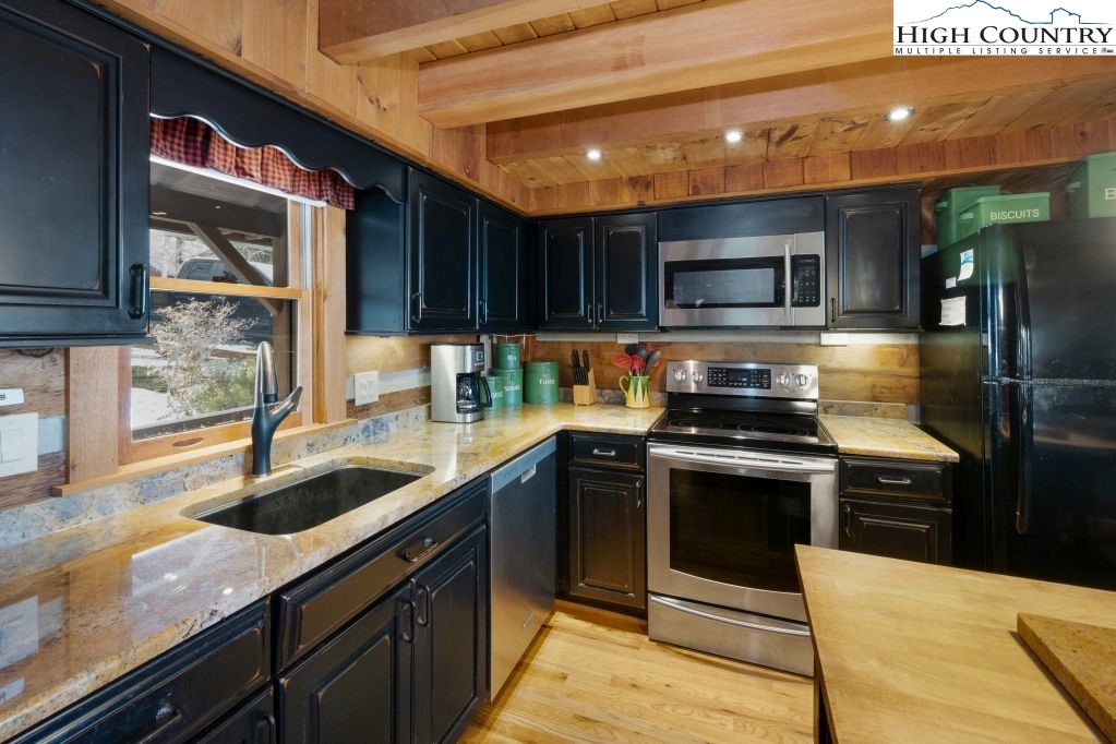126 Rock Spring Circle Sugar Mountain, NC 28604 - Photo 6 of 29 a kitchen with stainless steel appliances granite countertop a sink and a stove