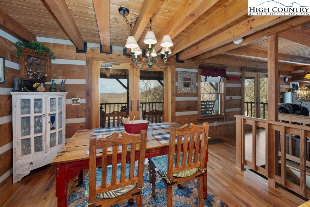 126 Rock Spring Circle Sugar Mountain, NC 28604 - Photo 8 of 29 a view of a dining room with furniture a chandelier and wooden floor