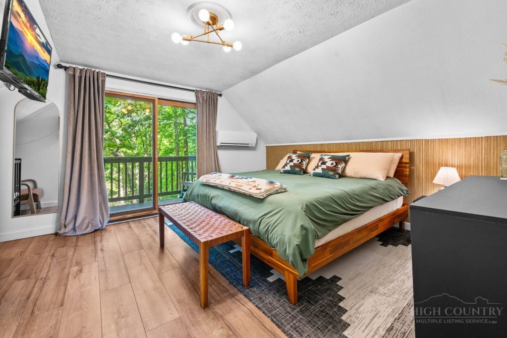 216 Saddle Lane Deep Gap, NC 28618 - Photo 17 of 44 a bedroom with a bed and a large window