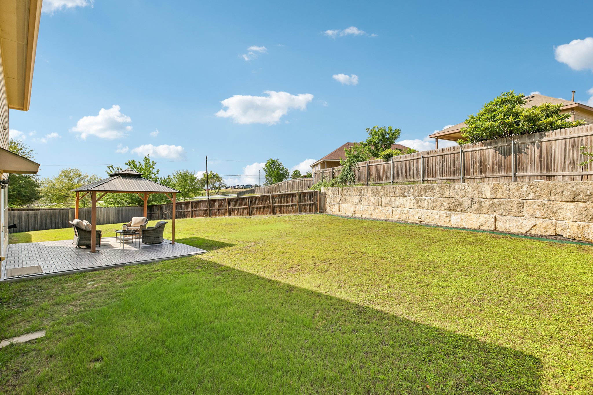 5508 Emma Thompson Way Austin, TX 78747 - Photo 5 of 34 Another view of the backyard showcases the beautiful stone accents and sense of privacy that make this outdoor space feel like your own private retreat.