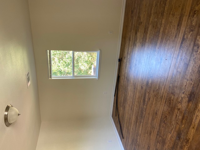 823 Monterrey Street Lockhart, TX 78644 - Photo 11 of 15 an empty room with wooden floor and windows