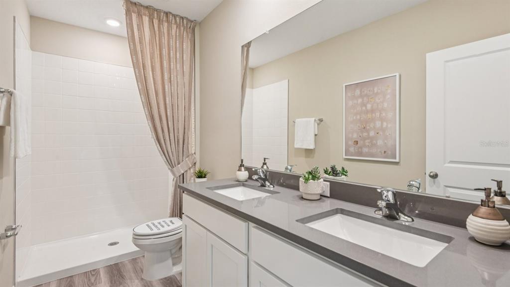 32511 Welling Blade Loop Wesley Chapel, FL 33545 - Photo 22 of 42 a bathroom with a double vanity sink and a mirror