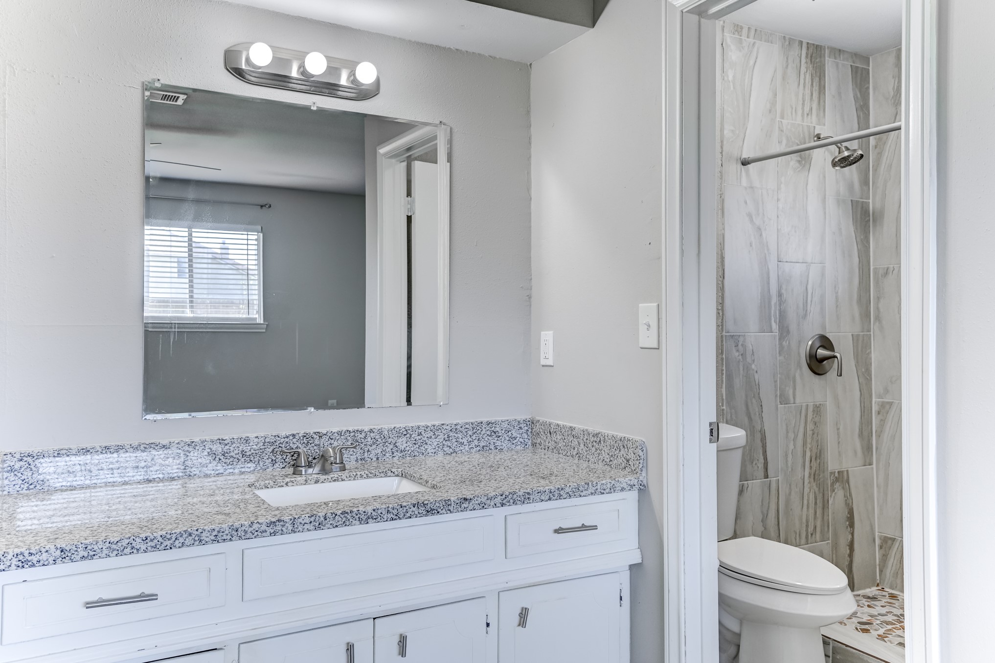 12415 Foxburo Drive Houston, TX 77065 - Photo 28 of 43 a bathroom with a granite countertop sink toilet a mirror and shower