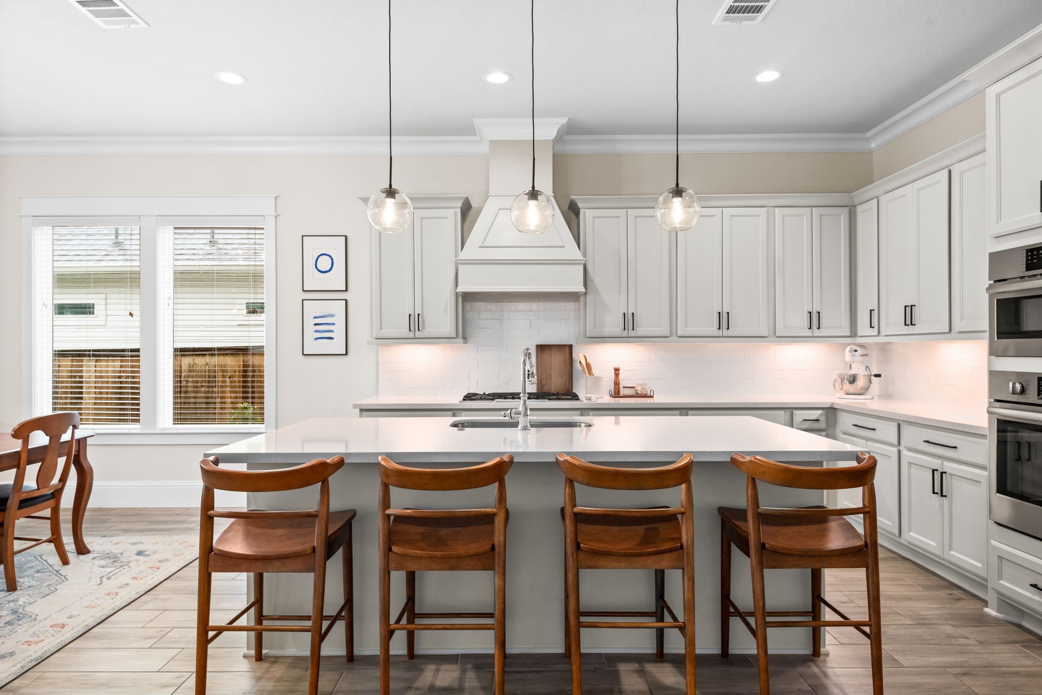 2335 Pale Star Drive Conroe, TX 77384 - Photo 14 of 42 a kitchen with stainless steel appliances granite countertop a stove a sink a kitchen island with chairs and white cabinets