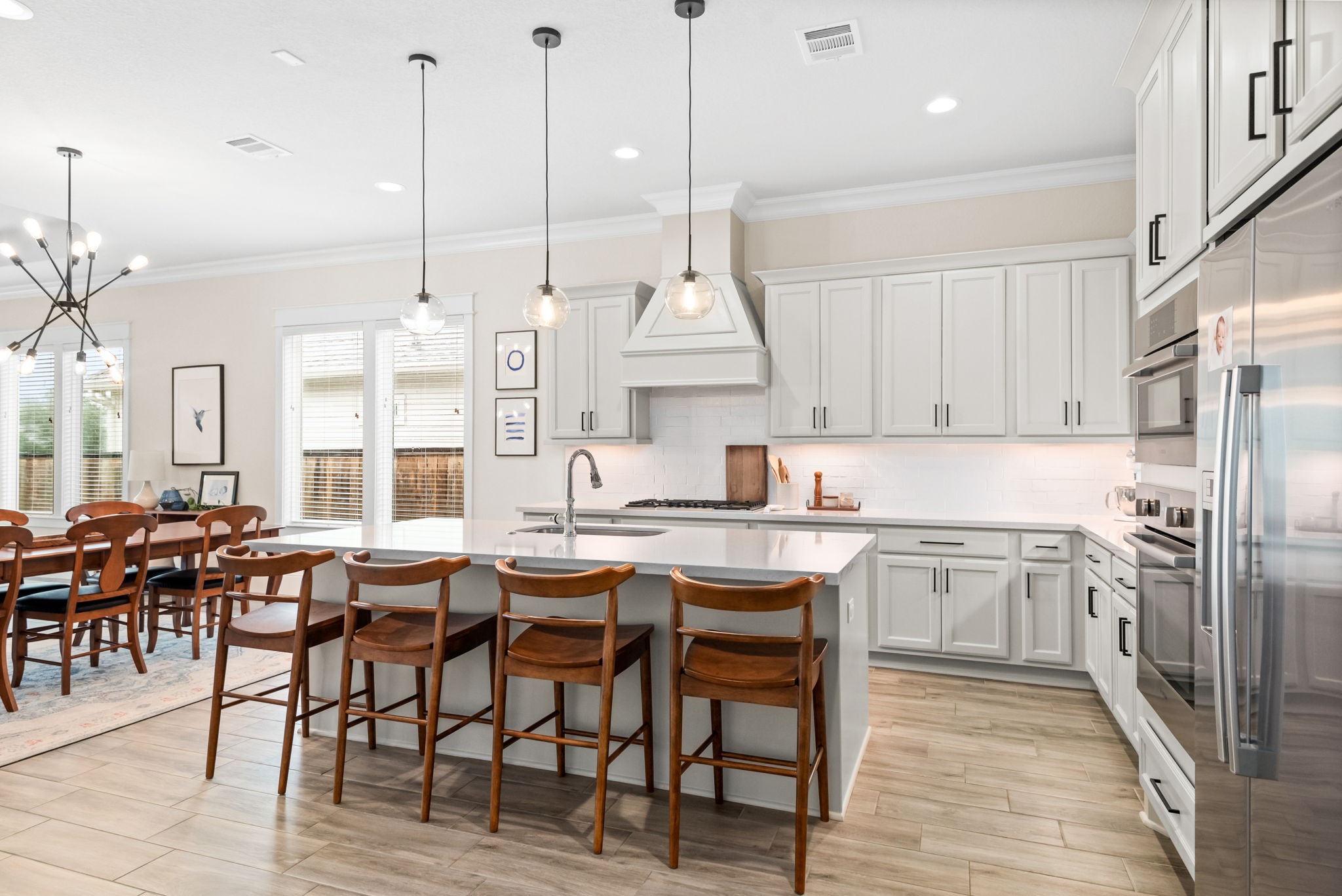 2335 Pale Star Drive Conroe, TX 77384 - Photo 15 of 42 a kitchen with stainless steel appliances kitchen island granite countertop a table chairs sink and cabinets