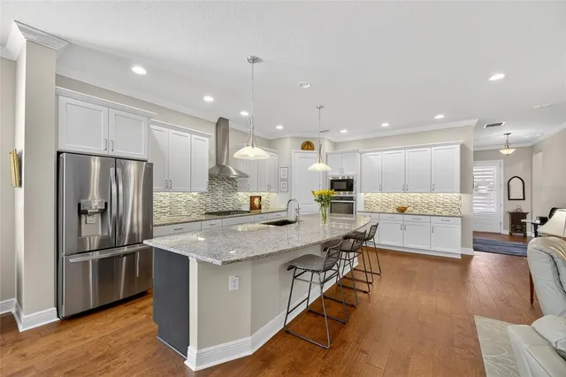 a living room with furniture kitchen view and a chandelier