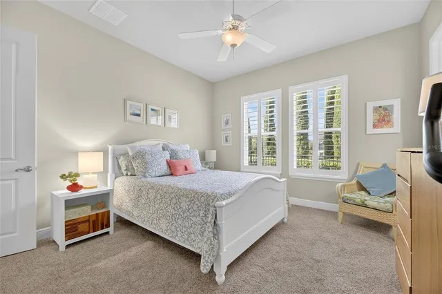 a bedroom with a bed a chandelier and dresser