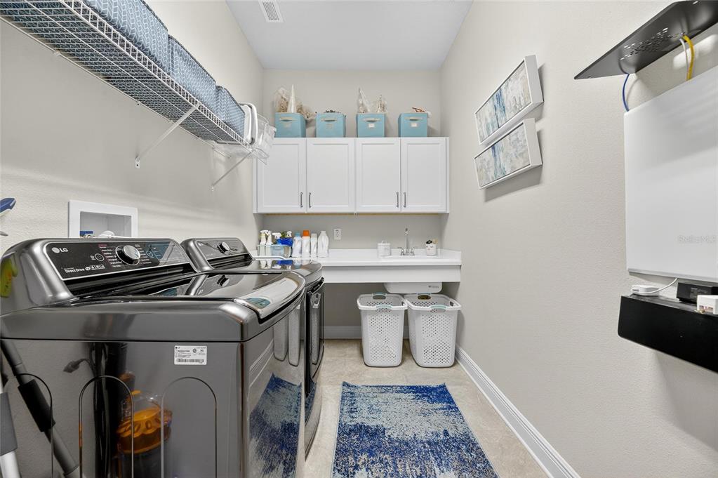 6002 Sparrowhead Way Lithia, FL 33547 - Photo 23 of 57 a utility room with dryer washer and a refrigerator