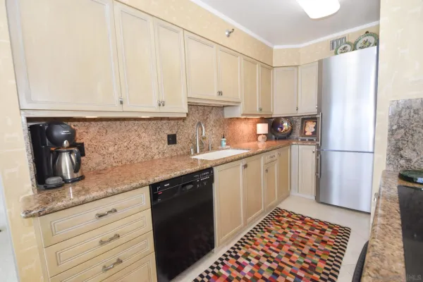 a kitchen with granite countertop a sink stove and refrigerator