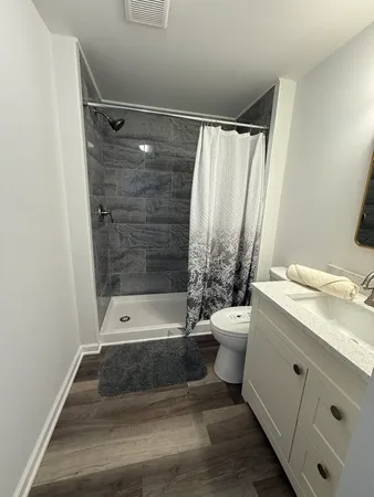 a bathroom with a granite countertop sink toilet and shower