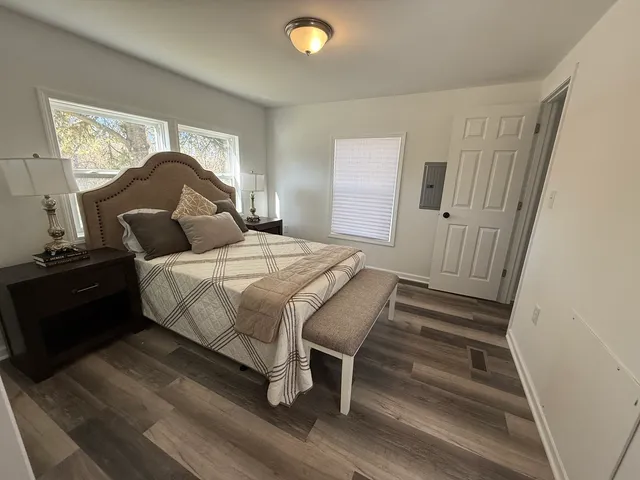 a bedroom with a bed and wooden floor