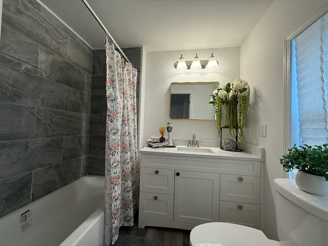 a bathroom with a sink a toilet and shower