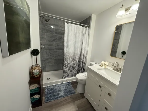 a bathroom with a sink a toilet and shower