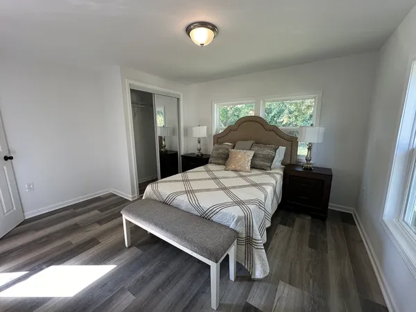 a bedroom with a bed and wooden floor