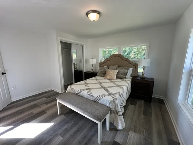 a bedroom with a bed and wooden floor