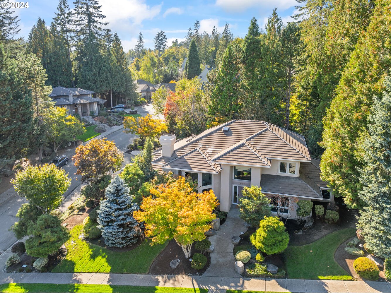 a front view of a house with a yard and garden