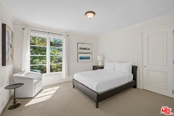 a bedroom with a large bed and a flat screen tv