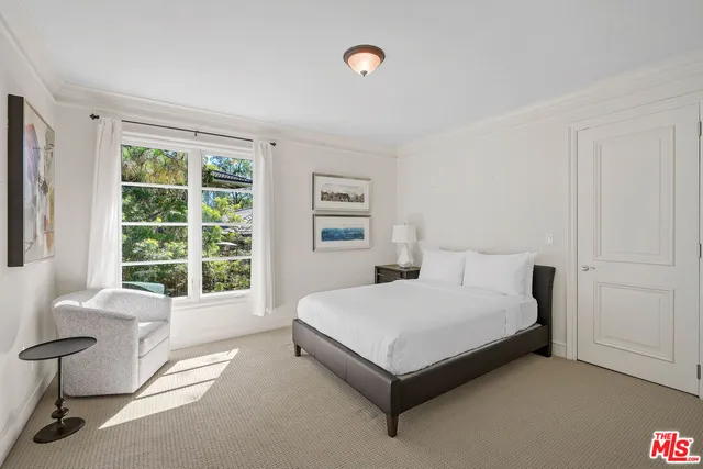 a bedroom with a large bed and a flat screen tv