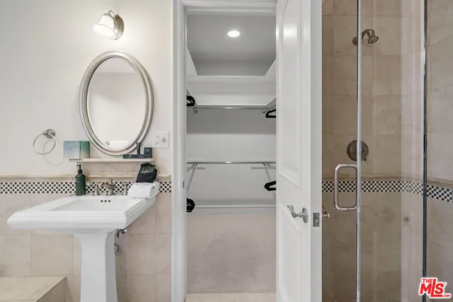 a kitchen with stainless steel appliances kitchen island granite countertop a refrigerator a sink dishwasher and white cabinets with wooden floor