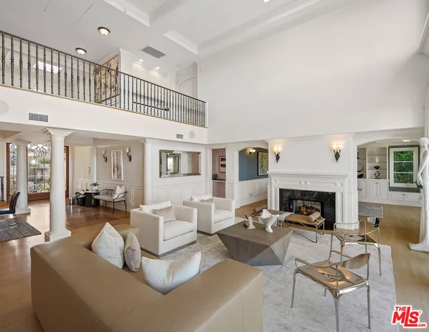 a living room with furniture a fireplace and a large window