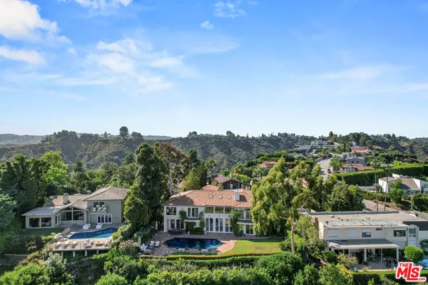 a front view of a house with a yard and potted plants