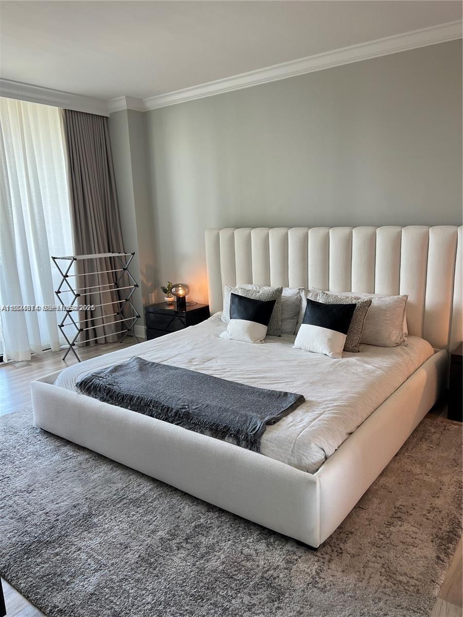 3400 Southwest 27th Avenue, Unit 1105 Miami, FL 33133 - Photo 12 of 24 a large bed sitting in a bedroom next to a window