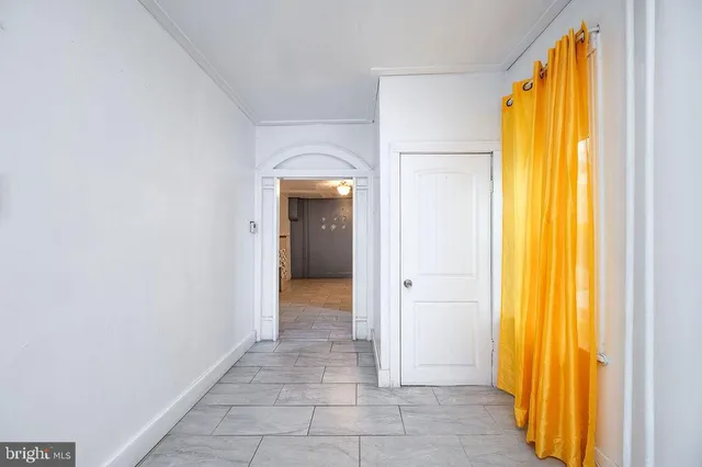 a view of an empty room with closet and a window