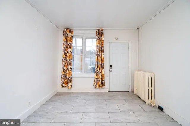 an empty room with windows and cabinet