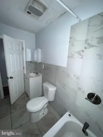 a white toilet sitting next to a bathroom sink and a shower