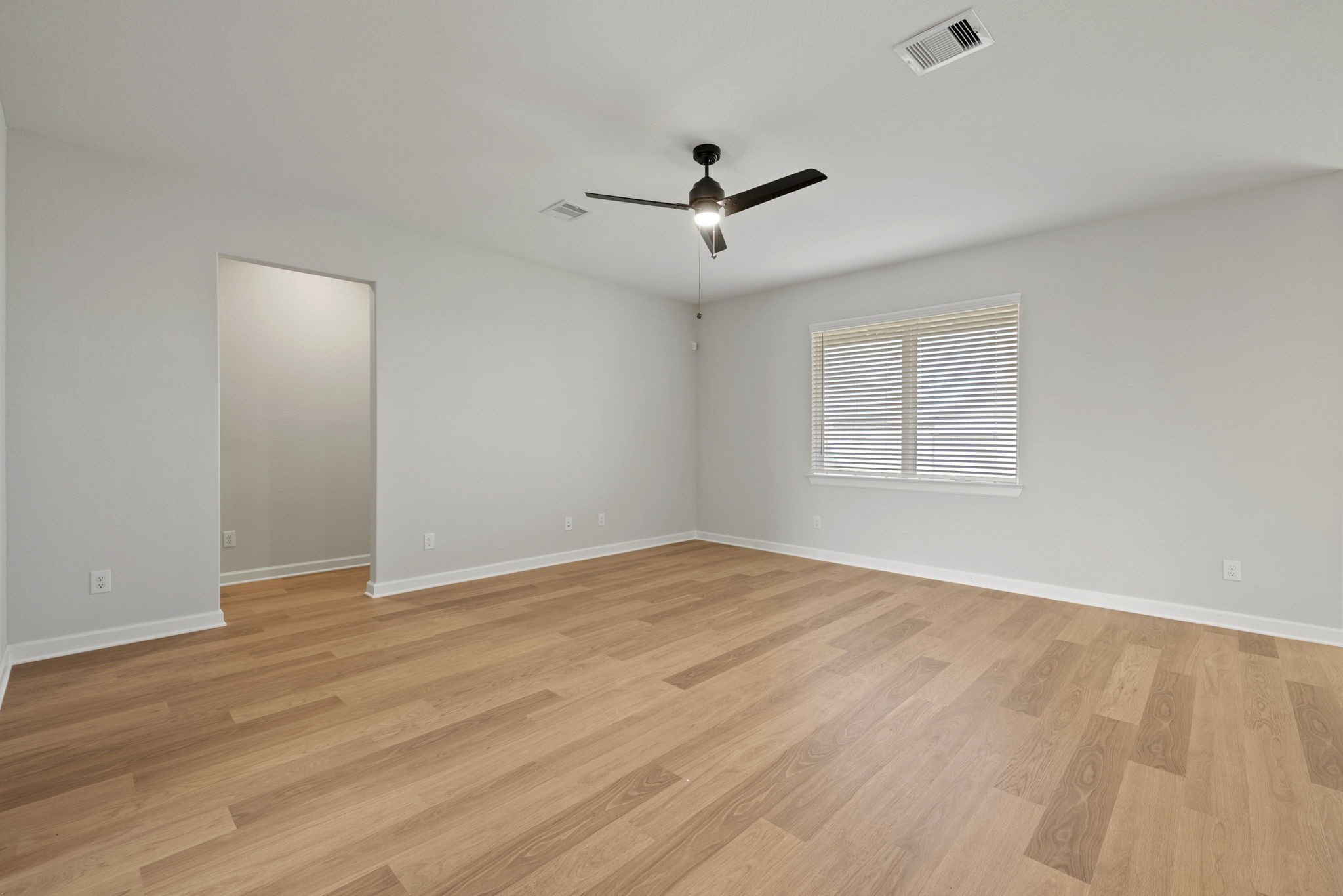 13601 Gaff Rig Drive Texas City, TX 77510 - Photo 5 of 20 an empty room with wooden floor ceiling fan and windows