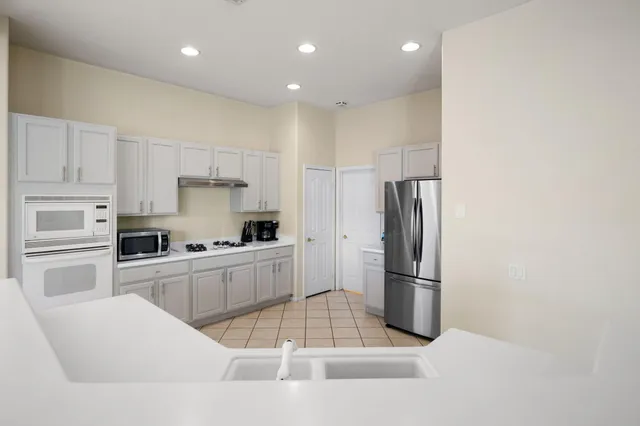 a kitchen with granite countertop a refrigerator oven stove and a sink