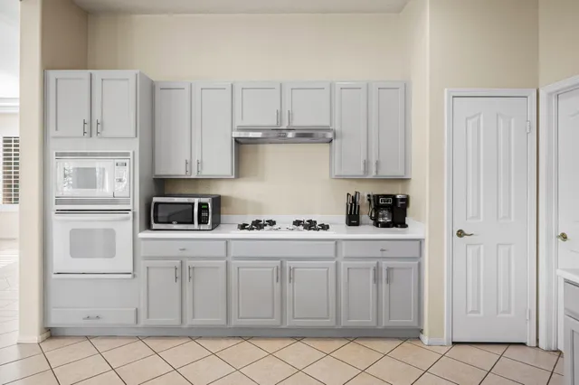 a kitchen with white cabinets and appliances