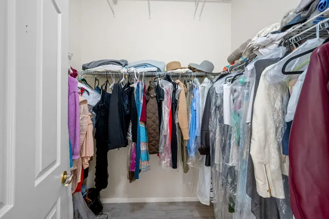a view of walk in closet with clothes