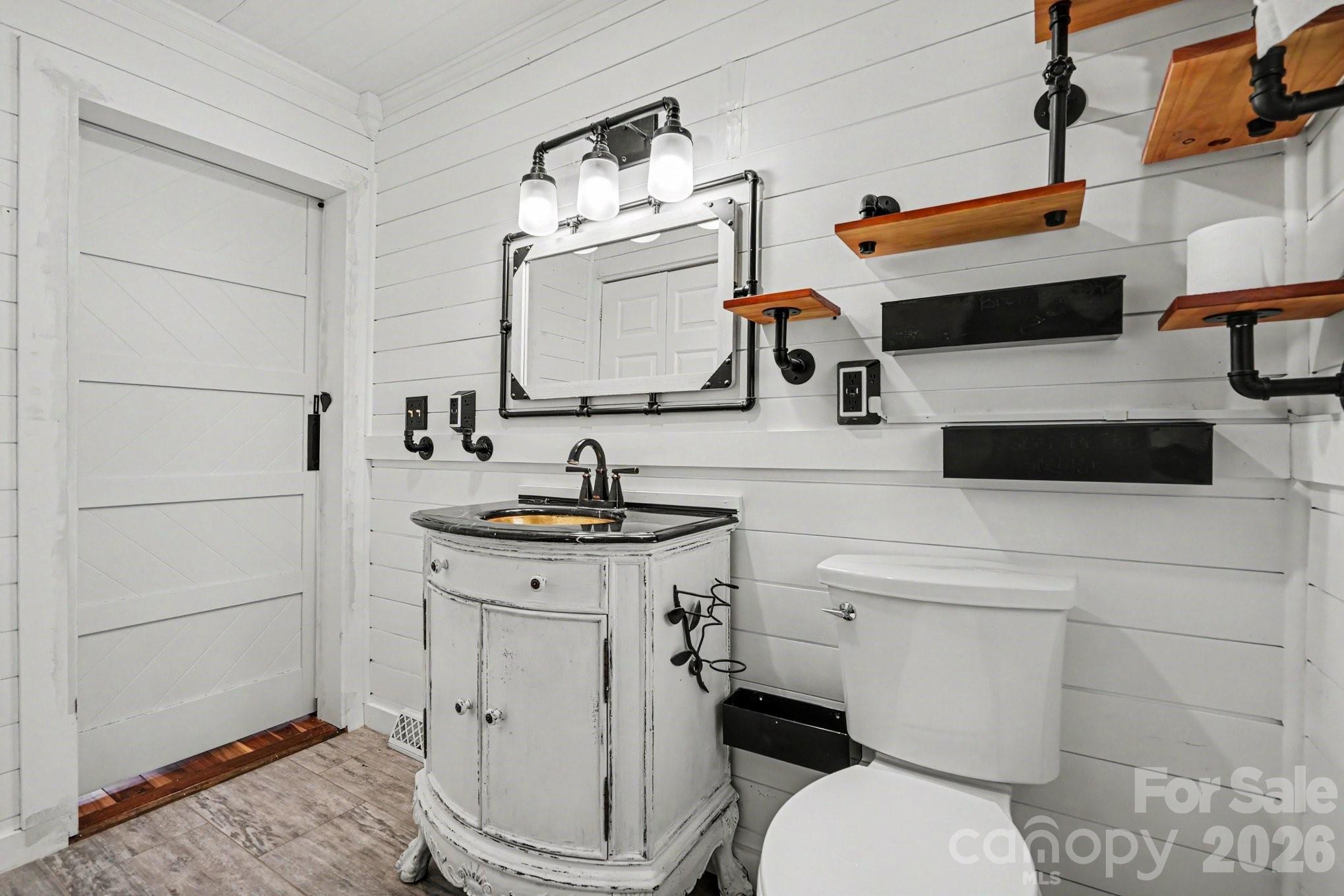 24359 Ridgecrest Road Locust, NC 28097 - Photo 12 of 26 a bathroom with a granite countertop toilet sink and mirror