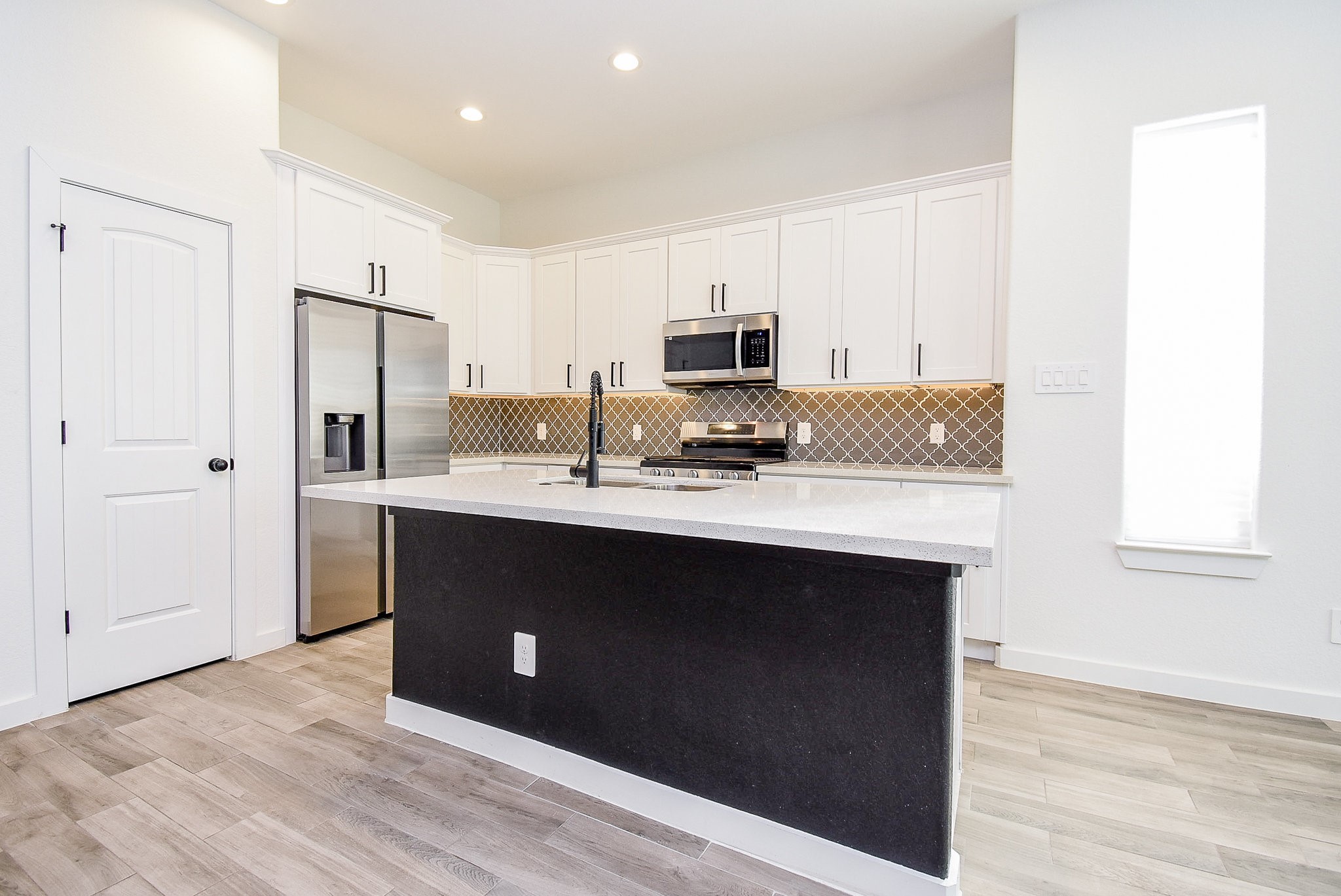 6828 Liverpool Street Houston, TX 77021 - Photo 8 of 32 a kitchen with kitchen island granite countertop a sink cabinets and stainless steel appliances