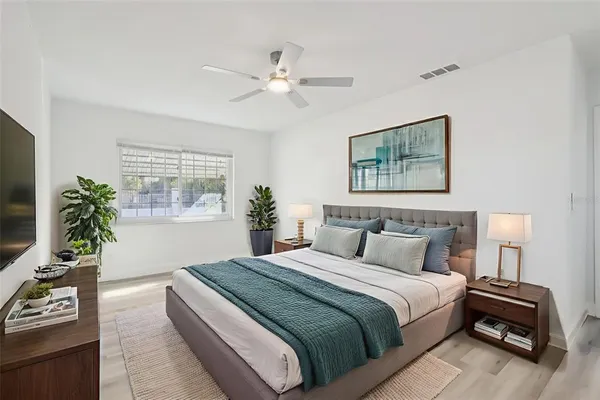a bedroom with a bed and a potted plant
