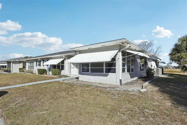 a view of a house with a yard and large tree