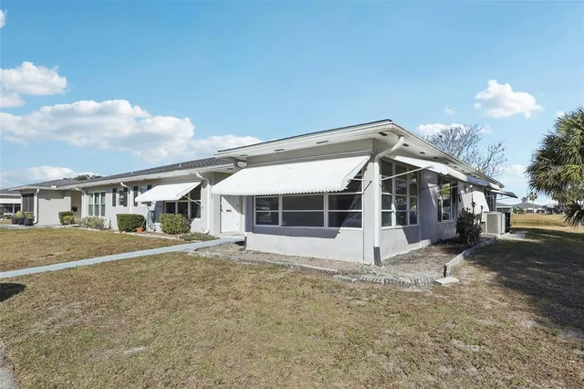 a view of a house with a yard and large tree