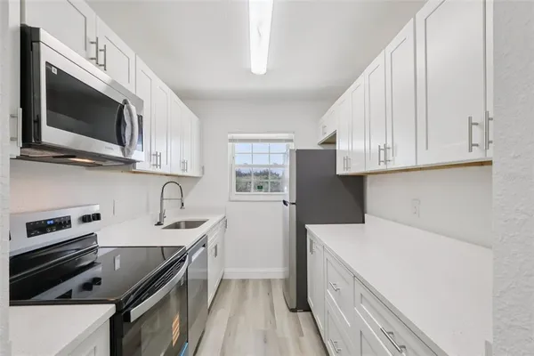 a kitchen with stainless steel appliances a stove microwave sink and cabinets