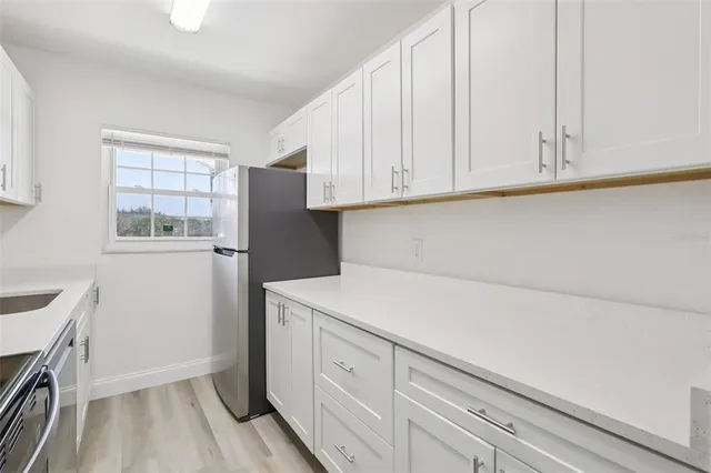 a kitchen with a white cabinets and a refrigerator