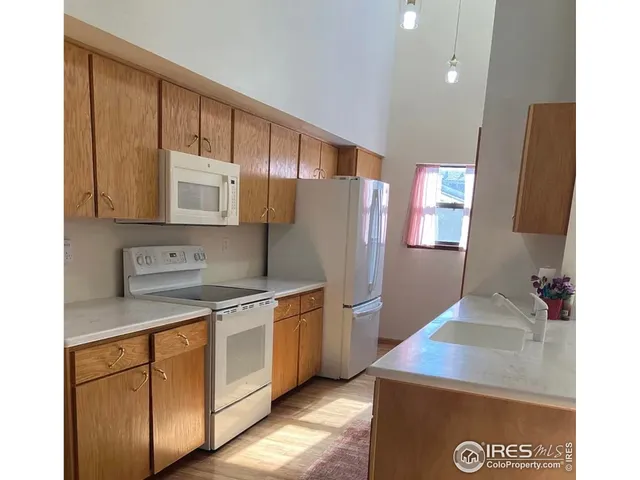a kitchen with a sink a refrigerator and cabinets