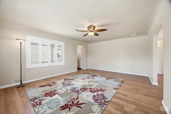 a view of a bedroom with wooden floor and a ceiling fan