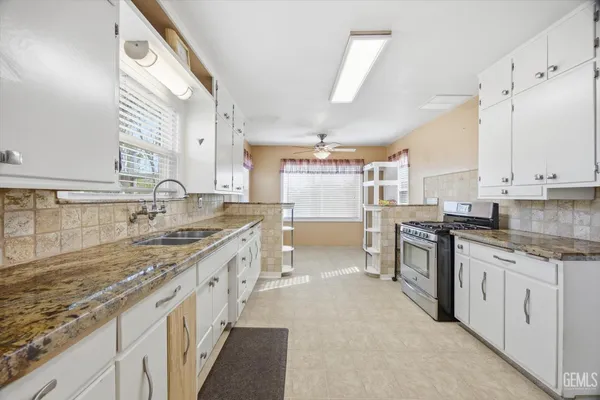 a large kitchen with stainless steel appliances granite countertop a lot of counter space and wooden floors