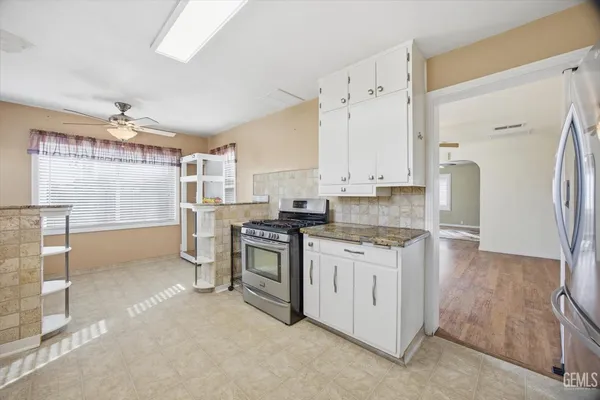 a kitchen with stainless steel appliances granite countertop a stove a sink and a refrigerator