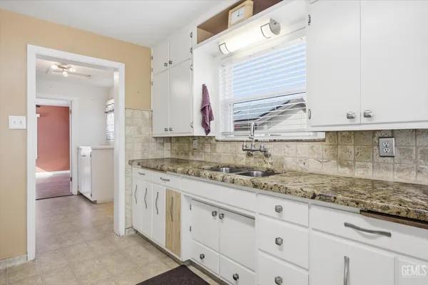 a bathroom with a granite countertop sink and a mirror