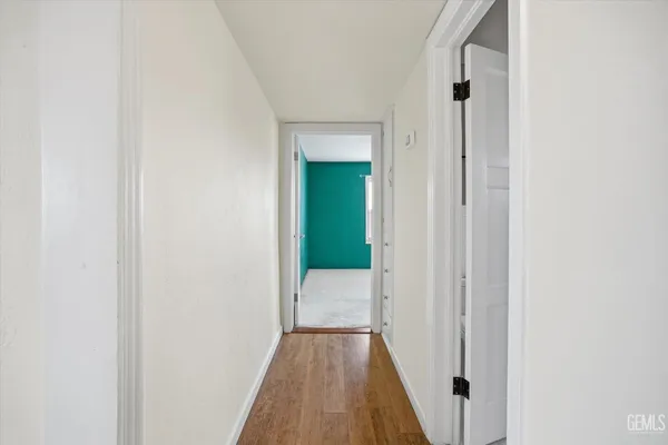 a view of a hallway with wooden floor
