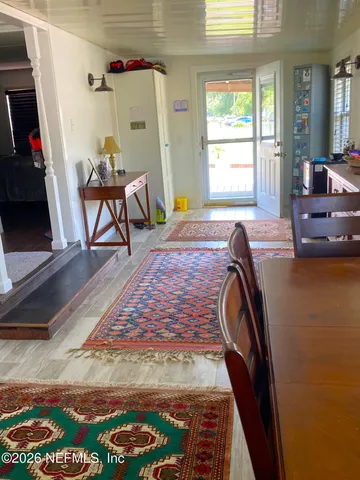 a living room with furniture mirror and wood floor