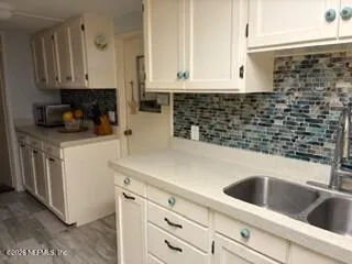 a kitchen with kitchen island a counter top space a sink and appliances