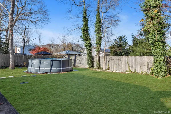 a view of a yard with a bench and trees