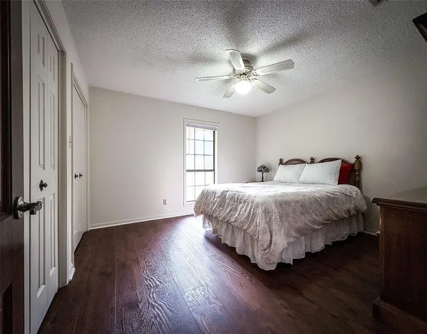 a spacious bedroom with a bed and wooden floor